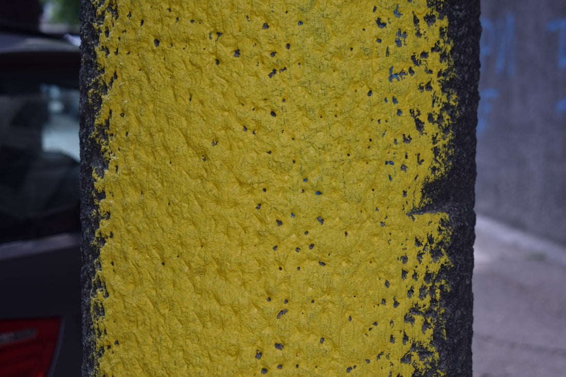 Yellow paint edges a dark, textured pole.