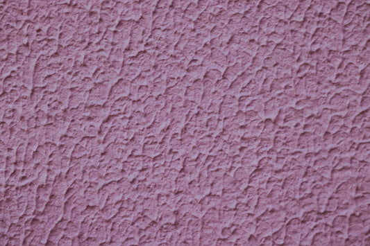 a close up of a pink stucco wall