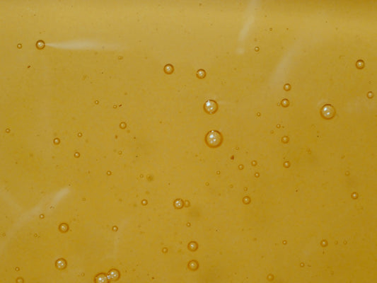 a close up of water bubbles on a yellow surface