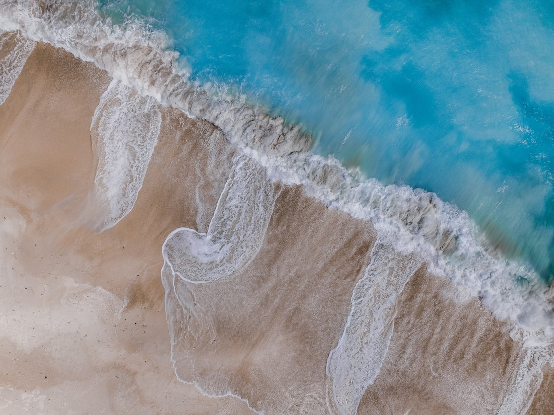 an aerial view of a beach with waves crashing on it