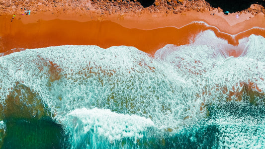 an aerial view of a beach with waves crashing on it