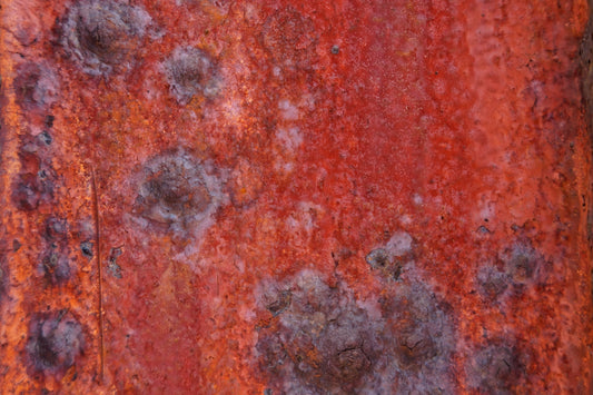 a rusted metal surface with small holes in it
