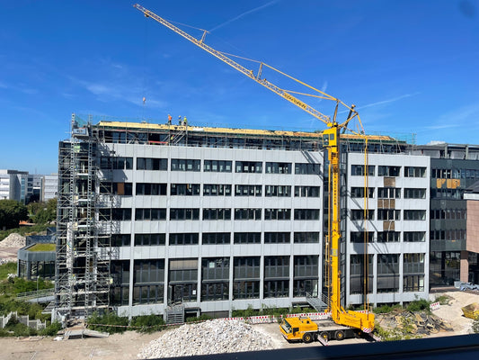 a crane is standing in front of a building under construction