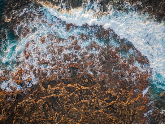 An aerial view of the ocean and rocks