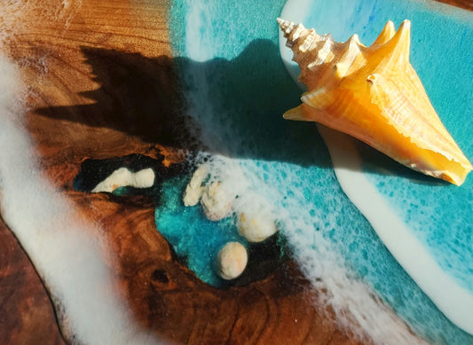 A seashell sits on a wave-like epoxy table.