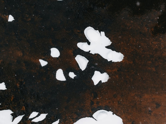 White ice formations on dark, textured surface