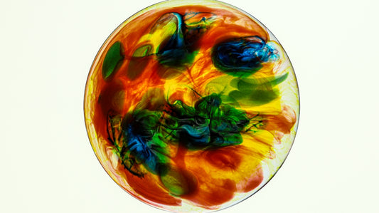 Abstract colorful swirls of paint in a glass orb.