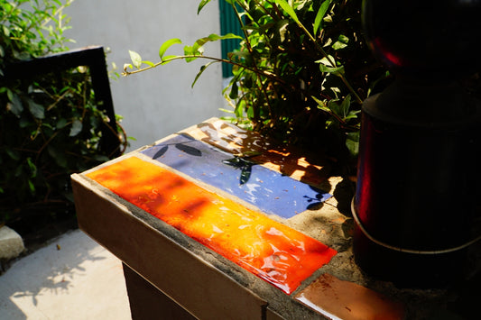 Colorful glass tiles arranged on a surface outdoors.